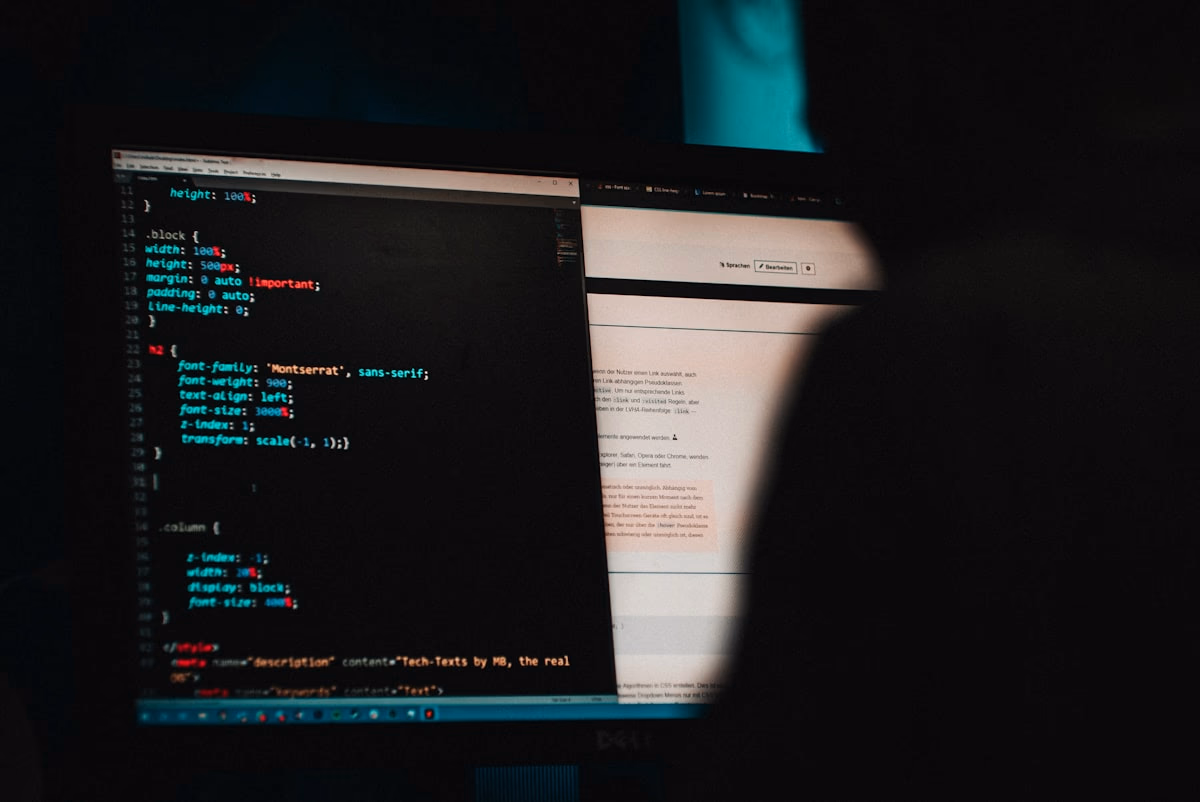 Developer reviewing code security on multiple monitors